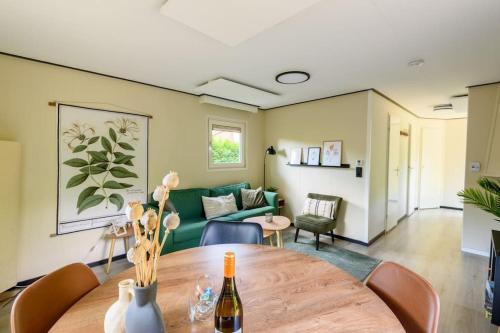 een woonkamer met een tafel en een bank bij Gezellig ingericht vakantiehuis op de Veluwe in Putten