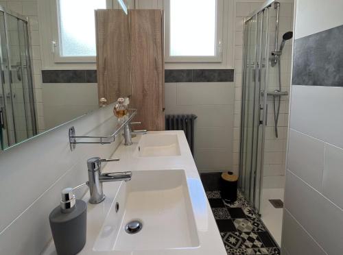 a bathroom with two sinks and a shower at Maison avec jardin centre ville in Saint Lo