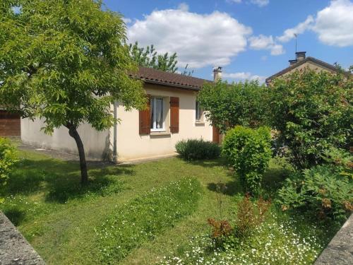 une maison avec une cour ornée d'arbres et de fleurs dans l'établissement L'Olivier Maison de village avec jardin au calme pour 6 pers, à Saint-Cyprien