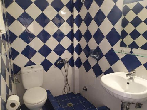 baño azul y blanco con aseo y lavabo en Armiriki sea view Guest home @Batsi Andros en Batsi