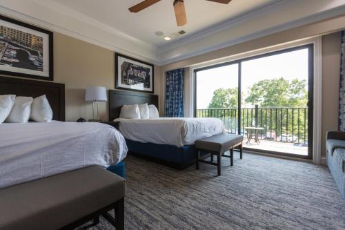 a hotel room with two beds and a balcony at Camden on the Lake Resort in Lake Ozark