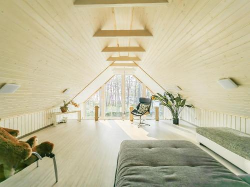 um grande quarto no sótão com uma cama e uma cadeira em River bank vacation home em Jūrmala