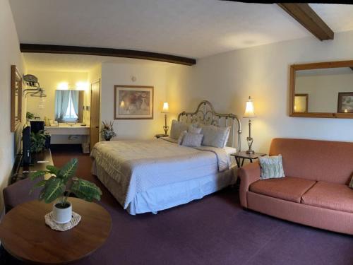 a bedroom with a large bed and a couch at Passion Play Road Inn - Formerly Statue Road Inn in Eureka Springs