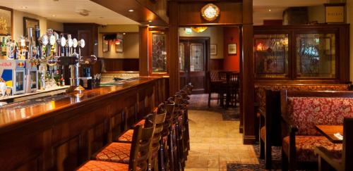 a bar with a row of chairs in a restaurant at Corr's Corner Hotel in Newtownabbey