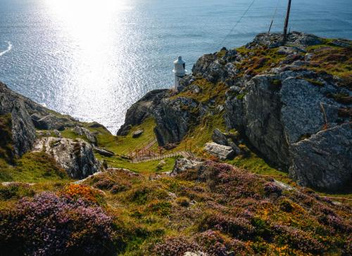 a lighthouse on the side of a cliff near the ocean at Bell View Holiday Home Sheeps Head by Trident Holiday Homes in Bantry