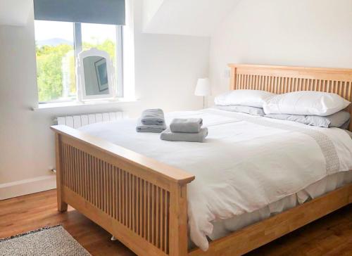 1 dormitorio con 1 cama grande con sábanas y almohadas blancas en Bell View Holiday Home Sheeps Head en Bantry