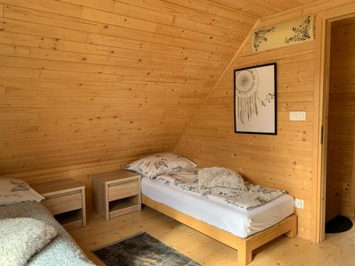 um quarto com duas camas num chalé de madeira em Domki Na Szlaku em Milówka