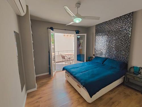 1 dormitorio con cama azul y balcón en Spot For Golf Lovers Villamartin, en Orihuela