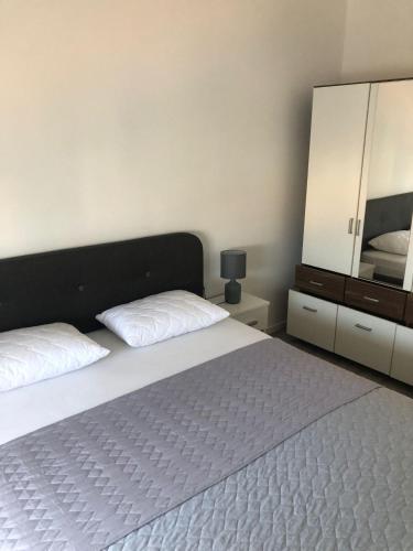 a bedroom with a bed and a dresser and a mirror at Apartment Centro 2 in Kastav