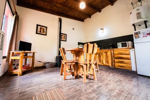 a kitchen with a table and chairs and a refrigerator at Sueño de Pehuenia in Villa Pehuenia