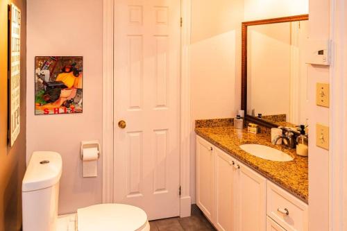 y baño con aseo, lavabo y espejo. en Luxurious condo (1100 sq2) /private elevator! en Quebec