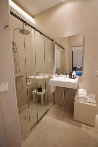 a bathroom with a glass shower and a sink at Casa Aura Hotel in Vejer de la Frontera