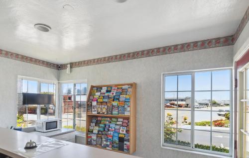 a room with windows and a desk with a computer at Discovery Inn Monterey Bay in Seaside