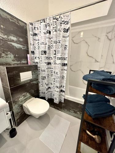 a bathroom with a toilet and a shower curtain at Oskar Wilde in Stará Ľubovňa