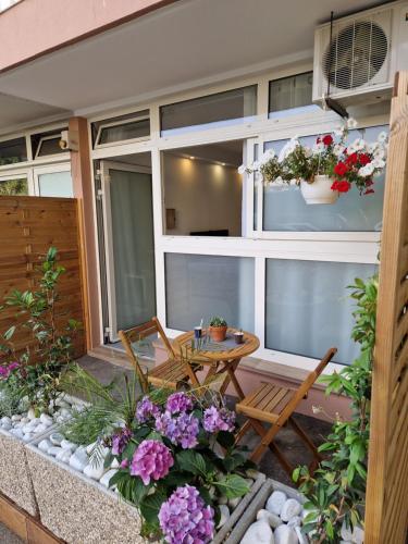 - une terrasse avec une table, des chaises et des fleurs dans l'établissement Souplex avec place de parking, à Antibes