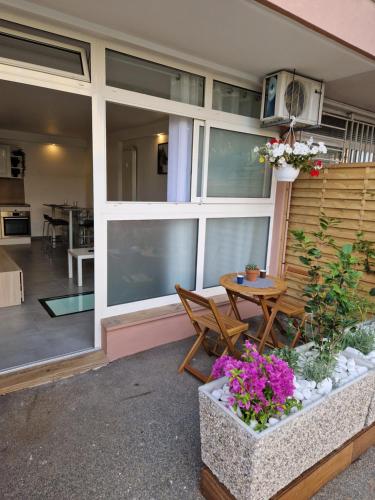 Cette maison dispose d'une terrasse avec une table et des fleurs. dans l'établissement Souplex avec place de parking, à Antibes