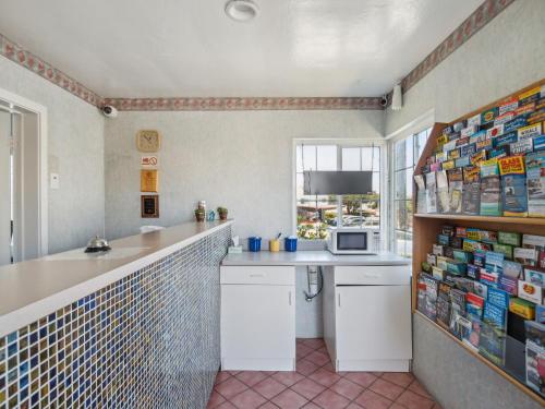 uma cozinha com um balcão, um lavatório e um micro-ondas em Discovery Inn Monterey Bay em Seaside