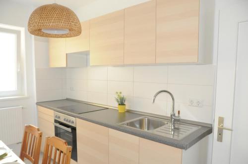 una cocina con armarios de madera y fregadero en Apartment Schmidt, en Berlín