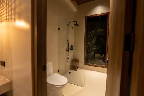 a bathroom with a toilet and a glass shower at Makani Luxury Wanderlust in Tierra Bomba