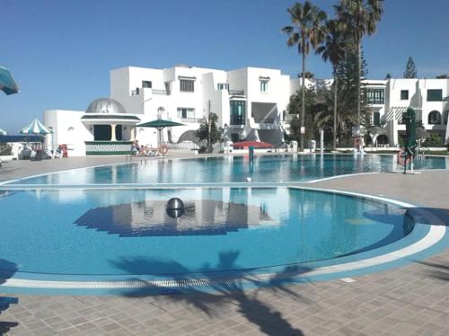 una gran piscina frente a un edificio en Charmant Studio vue mer @Kantaoui - 1min à pied de la plage en Hammam Sousse
