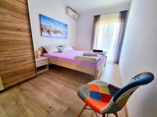 a small bedroom with a bed and a chair at Julia in Biograd na Moru