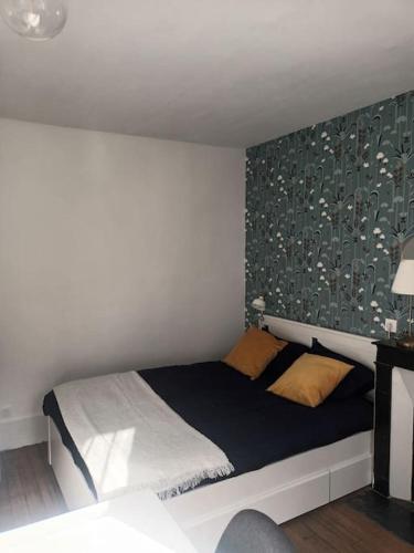 a bedroom with a bed with a wall at Très Parisien et ensoleillé in Paris