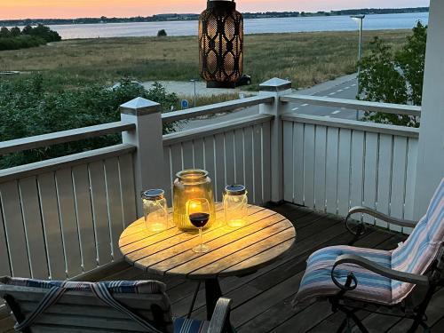 a wooden table with two glasses of wine on a deck at Villa Wiegand - a room with a view in Holbæk