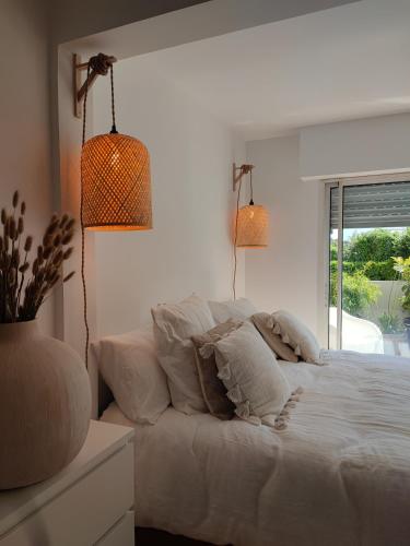 une chambre avec un lit blanc et une fenêtre dans l'établissement La suite appartement plages et centre ville a pied, à Concarneau