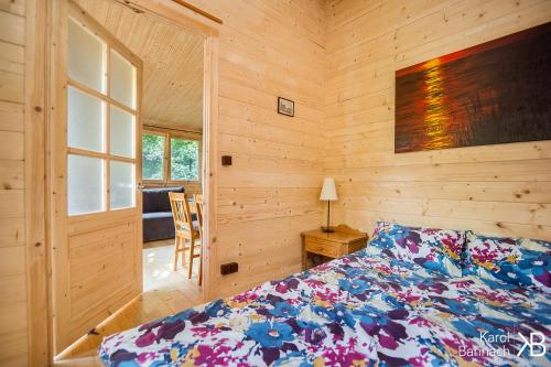 sypialnia z łóżkiem i drewnianą ścianą w obiekcie Mazurskisen w mieście Mrągowo