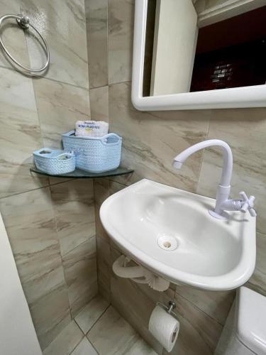 a bathroom with a sink and a mirror at Pousada Dona Felicidade Carneiros in Tamandaré