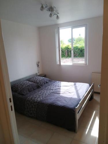 une chambre avec un lit dans une pièce avec une fenêtre dans l'établissement Maison à Mézières-en-Brenne 