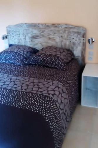 - une chambre avec un grand lit avec une tête de lit dans l'établissement Maison à Mézières-en-Brenne 