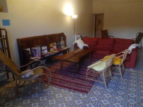 sala de estar con sofá rojo y sillas en Fonda Can Llobet, en Santa María del Camí