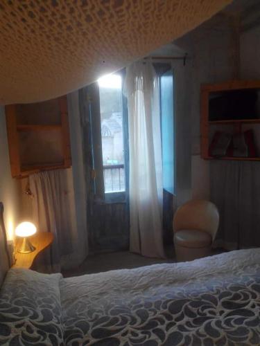 1 dormitorio con cama, ventana y silla en Fonda Can Llobet, en Santa María del Camí