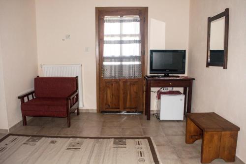 a living room with a television and a chair at Varnous Hotel in Agios Germanos