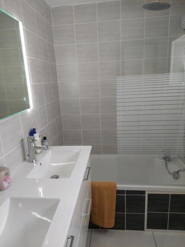 ein weißes Badezimmer mit einem Waschbecken und einer Badewanne in der Unterkunft L'hacienda de Maria montchanin in Montchanin