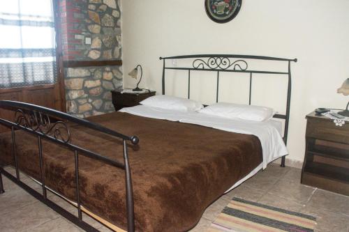a bedroom with a large bed with a metal frame at Varnous Hotel in Agios Germanos