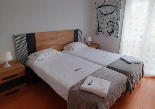 1 dormitorio con 2 camas y toallas. en ESS01256 Vivienda situada en la calle Mitxelena en Zarautz