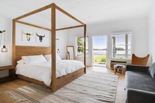 1 dormitorio con cama con dosel y sofá en 25 Bedrooms - Retreat Center Waterfront Renovated, 