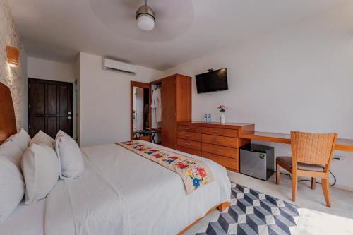 a bedroom with a large white bed and a desk at Casona Las Tres Marías - Hotel Only adults in Mérida