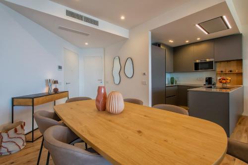 a kitchen and dining room with a wooden table and chairs at Sea inside luxury apartment: vista mozzafiato in Alghero