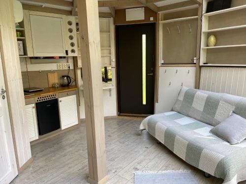 ein Wohnzimmer mit einem Sofa und einer Küche in der Unterkunft Mugavustega majake mereäärses männikus. in Lohusalu