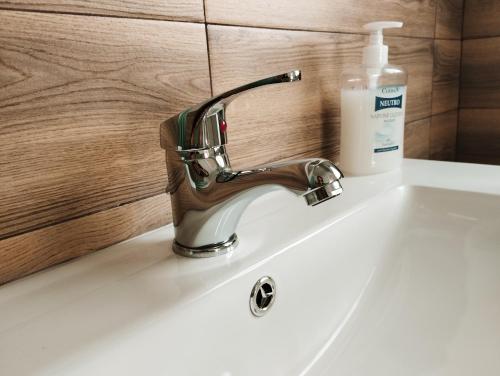 a bathroom sink with a soap bottle on it at Thomas'home in Comiso