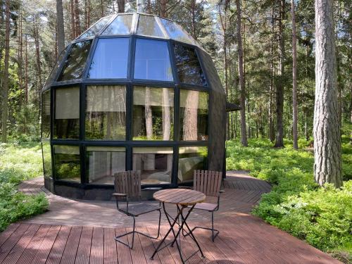 Casa con cúpula de cristal con 2 sillas y mesa en Mugavustega majake mereäärses männikus., en Lohusalu