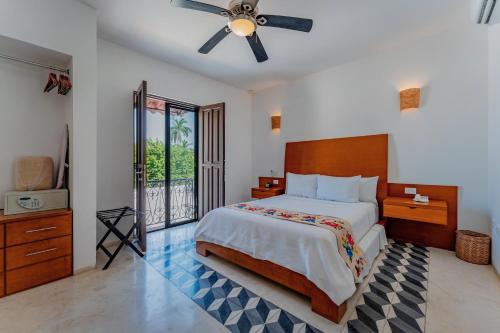 a bedroom with a large bed with a ceiling fan at Casona Las Tres Marías - Hotel Only adults in Mérida