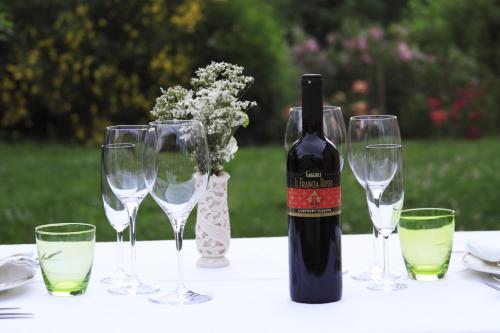 a bottle of wine sitting on a table with wine glasses at Agriturismo Gaggioli Borgo Delle Vigne in Zola Predosa