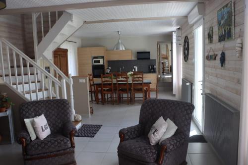 a living room with two chairs and a kitchen at Maison de vacances avec jardin clos à 300m de la mer in Pouldreuzic