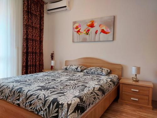 a bedroom with a bed and a painting on the wall at Apartament Holiday in Mamaia Nord