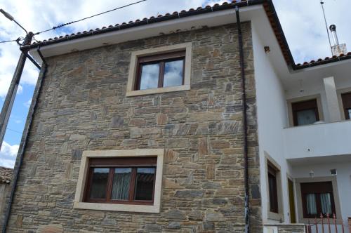 a building with three windows on the side of it at Maria's Country House in Miranda do Douro