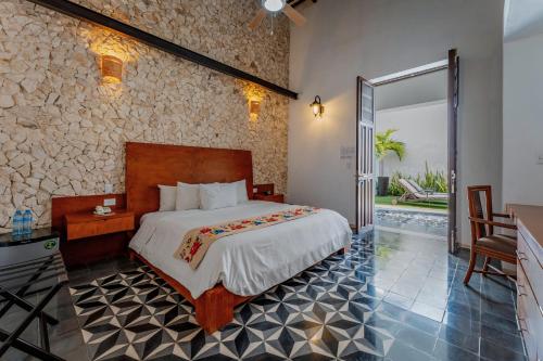 a bedroom with a bed and a stone wall at Casona Las Tres Marías - Hotel Only adults in Mérida